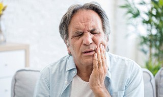 An older man suffering from a toothache