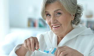 A senior woman preparing to brush her teeth